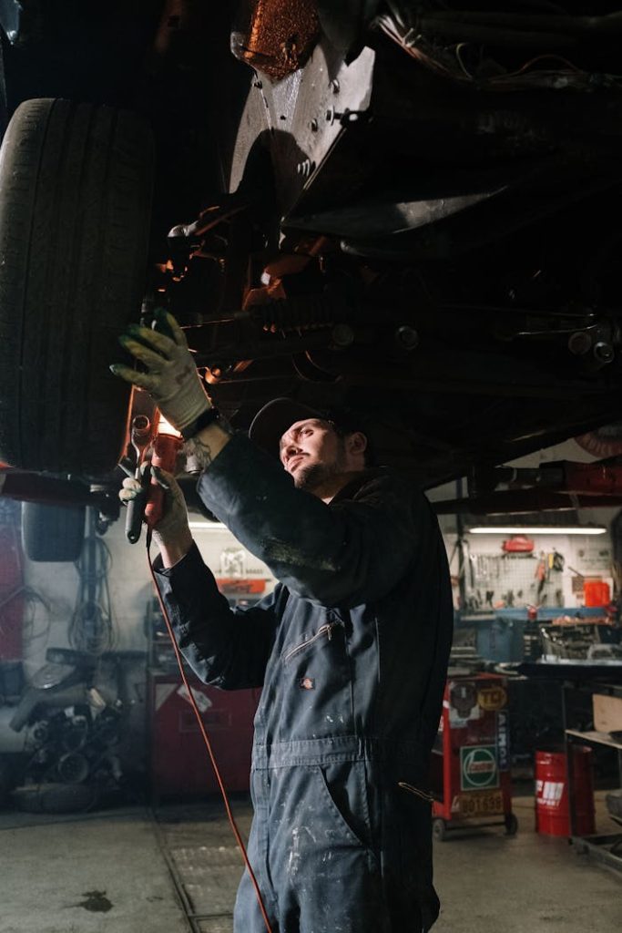pexels-photo-4489746 Mechanic working on a car maintenance in a well-equipped garage setting.